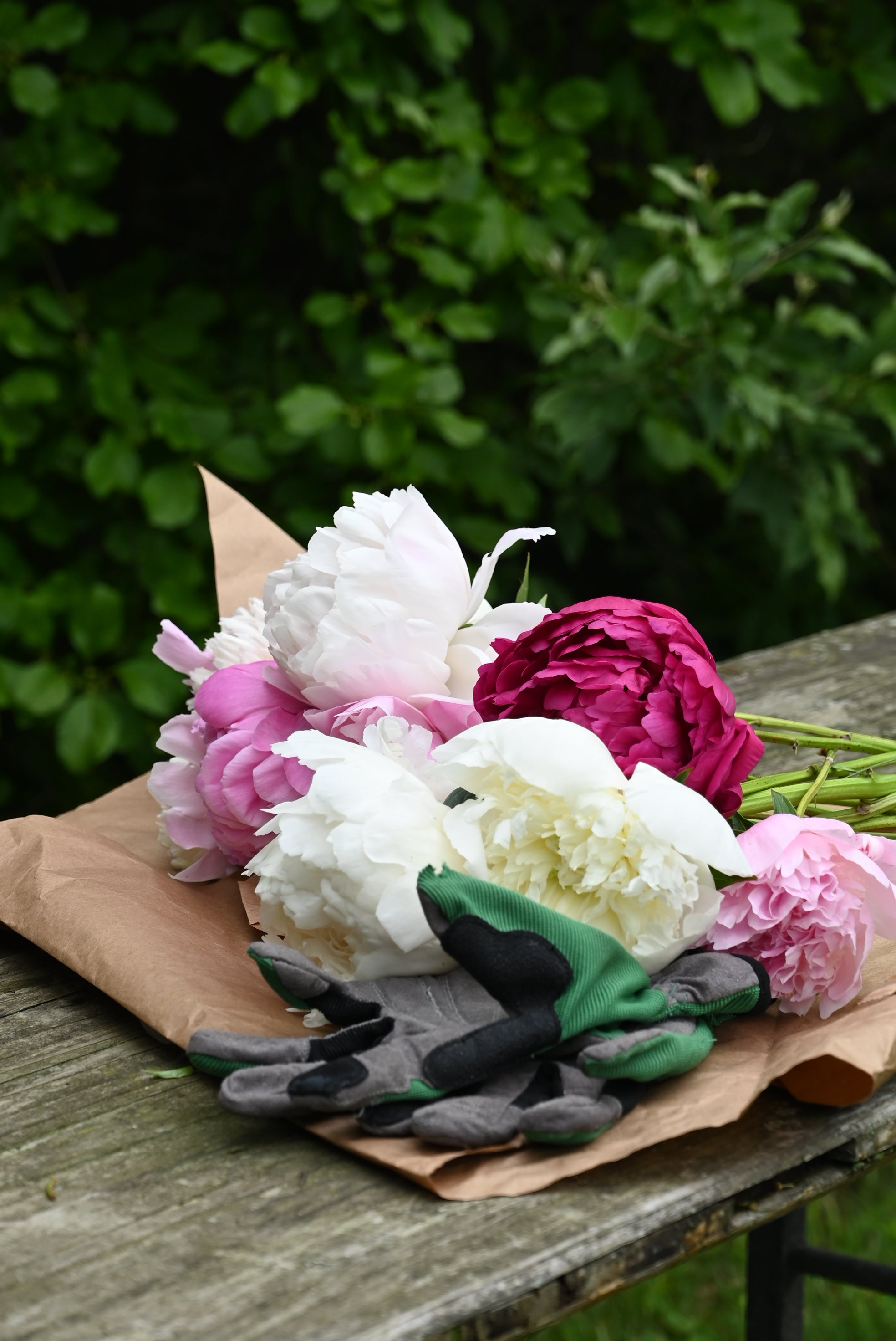 Bouquet of flowers on a wooden surface with greenery in the background